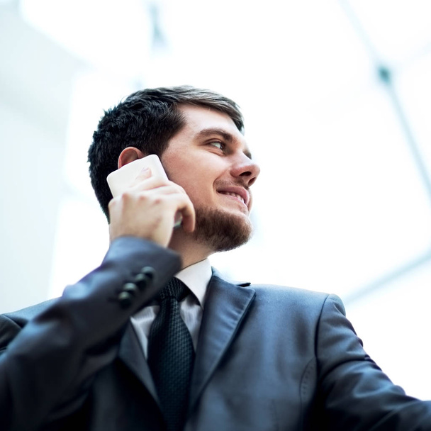Young business man talking on cell phone at modern office - 写真・画像