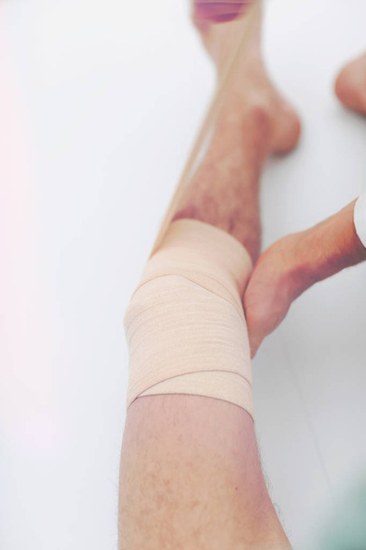 closeup. doctor bandaging a patients leg - 写真・画像