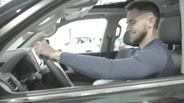 Rodzaju zbliżenie szczęśliwy człowiek siedzi w nowy samochód. - Materiał filmowy, wideo