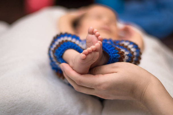 Ouder houden in de handen voeten van pasgeboren baby. - Foto, afbeelding