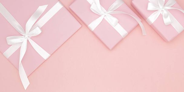 Valentine tai naisten päivä vaaleanpunainen lahja valkoinen keula nauha koralli paperi tausta. Käsite sisustus rakkaus päivä tai syntymäpäivä. Litteä pano. Kopioi tila
 - Valokuva, kuva
