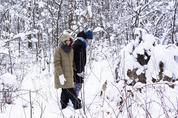 A srác a lány séta a havas erdőben. - Fotó, kép