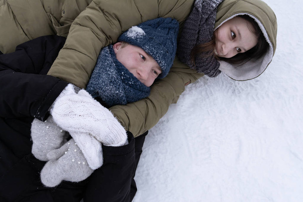雪の中でうなるとお互いを抱き締める男と少女. - 写真・画像