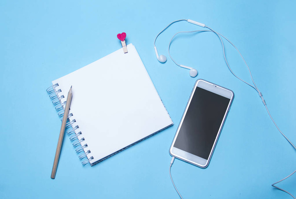 a notebook and a smartphone with headphones - Fotoğraf, Görsel