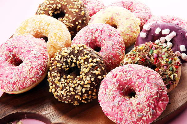 assorted donuts with chocolate frosted, pink glazed and sprinkles donuts. - Photo, Image