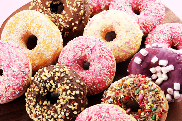 assorted donuts with chocolate frosted, pink glazed and sprinkles donuts. - Photo, Image