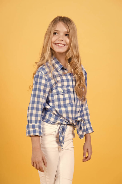 Girl with long blond hair smile on orange background - Фото, зображення