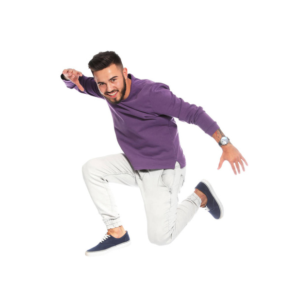 Handsome young man jumping on white background - Foto, Imagen