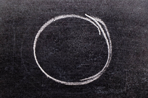 Wit krijt hand puttend zwarte bord achtergrond in de cirkel of ronde vorm - Foto, afbeelding