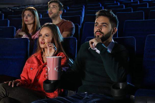 Jongeren eten popcorn tijdens showtime in Theater bioscoop - Foto, afbeelding