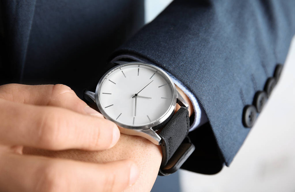 Бизнесмен заворачивает наручные часы крупным планом. Управление временем
 - Фото, изображение