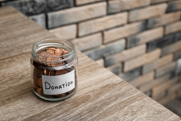 Donation jar with coins on table. Space for text - Фото, изображение