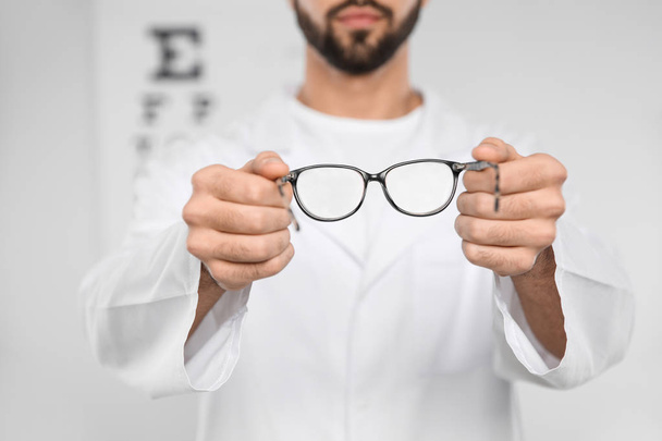 Male ophthalmologist with eyeglasses in clinic, closeup - 写真・画像