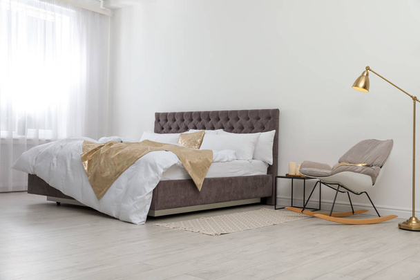 Large comfortable bed in stylish room. Modern interior design - Foto, Imagem