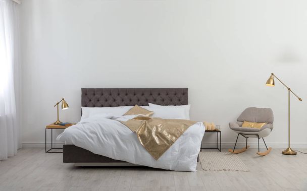 Large comfortable bed in stylish room. Modern interior design - Foto, imagen
