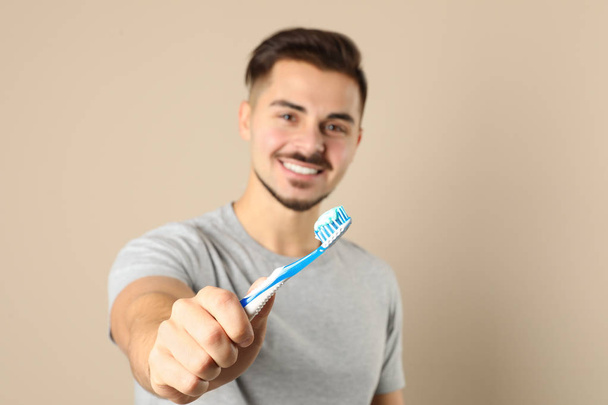 Young man with toothbrush on color background, space for text. Teeth care - Foto, Imagem