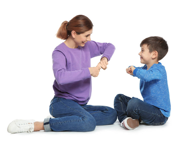 Zaburzenia słuchu, matka i dziecko rozmawia z pomocą języka migowego na białym tle - Zdjęcie, obraz