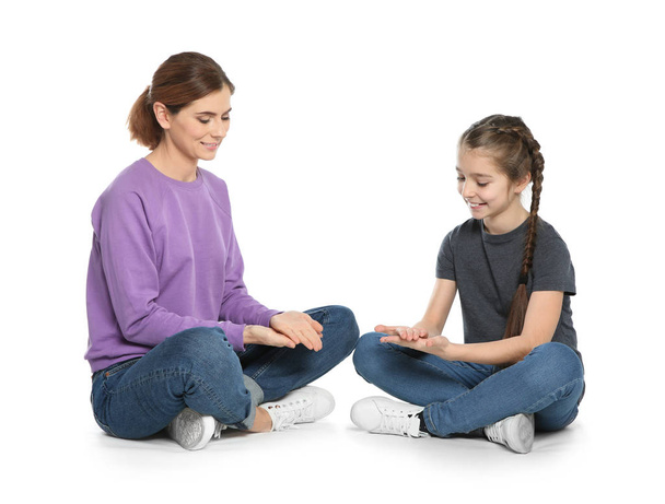 Hearing impaired mother and her child talking with help of sign language on white background - Φωτογραφία, εικόνα