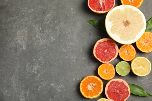 Different citrus fruits on grey background, top view. Space for text - Fotó, kép