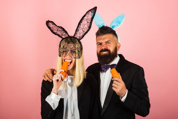 Funny easter. Cute bunny rabbit couple. Easter bunny dress. Happy easter egg couple eat carrot. - Zdjęcie, obraz