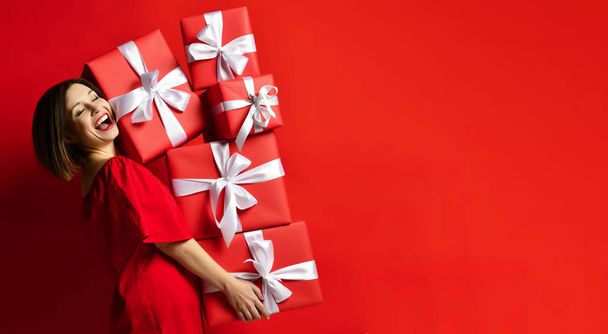 Joyful woman holding a lot of boxes with gifts - Foto, imagen