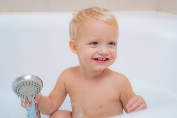 Kids fun bath. Bath. Happy childhood. Hygiene and care for young children. Adorable little boy smiling while take a bath in bathroom. - Photo, image