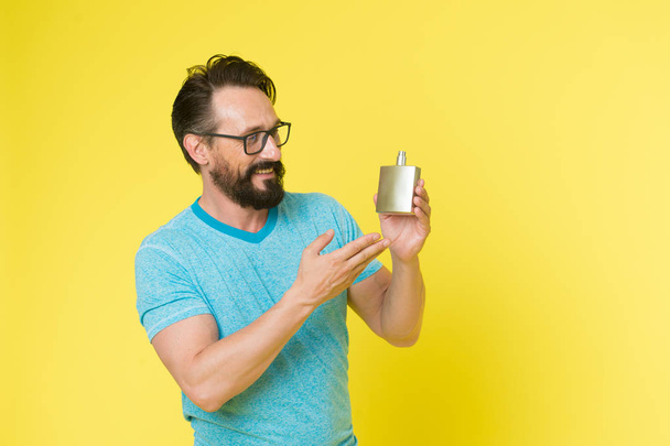 How choose perfume for men according to occasion. Make sure smell fresh throughout day. Wearing perfume is enhancing mood. Amazing benefits of using perfumes. Man bearded handsome hold bottle perfume - Zdjęcie, obraz