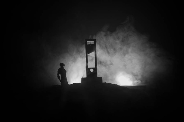 Vista horrenda da Guilhotina. Humano na guilhotina com um fundo de nevoeiro escuro. Conceito de execução
 - Foto, Imagem
