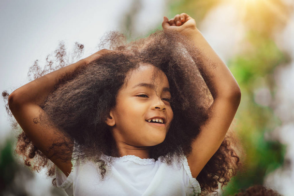 Портрет счастливого афроамериканского ребенка, играющего в открытом парке. Свобода и здоровье детей
. - Фото, изображение