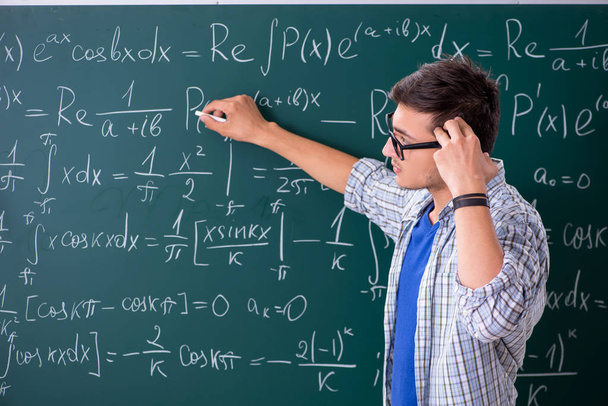 Молодой мужчина, изучающий математику в школе
 - Фото, изображение