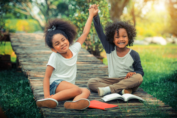Happy little boy and girl in the park. Two African American children together in the garden. - Photo, Image