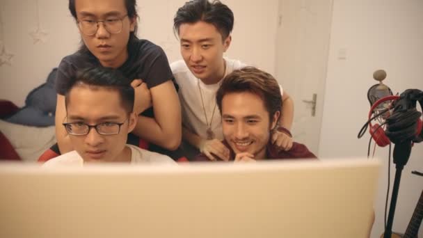 group of four young asian musician working together editing music using desktop computer. - Felvétel, videó
