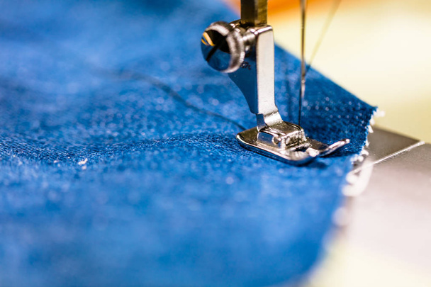 Sewing denim jeans with sewing machine. Repair jeans by sewing machine. Alteration jeans, hemming a pair of jeans, handmade garment industrial concept - Zdjęcie, obraz