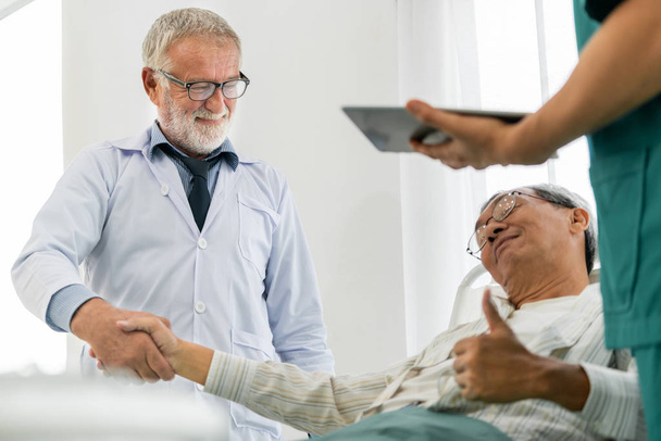 Зрелый врач говорит и осматривает здоровье пожилого пациента в стационаре. Концепция медицинского обслуживания и обслуживания персонала
. - Фото, изображение