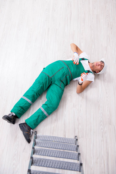 Молодой рабочий падает с лестницы
  - Фото, изображение