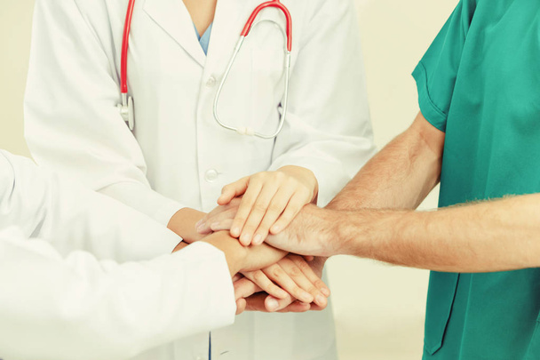 Medical service teamwork - Doctor, surgeon and nurse join hands together. - Foto, Bild
