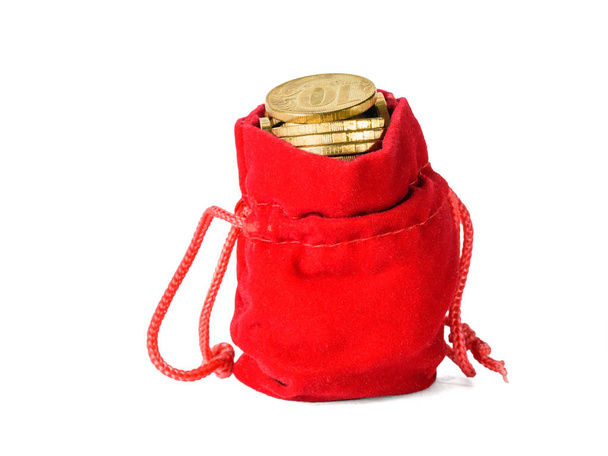 Red bag filled with coins isolated on white background. The concept of saving cash savings. - Photo, Image