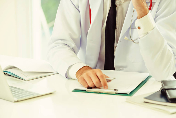 Doctor working with paperwork at office table in the hospital. Medical and healthcare concept. - Photo, Image