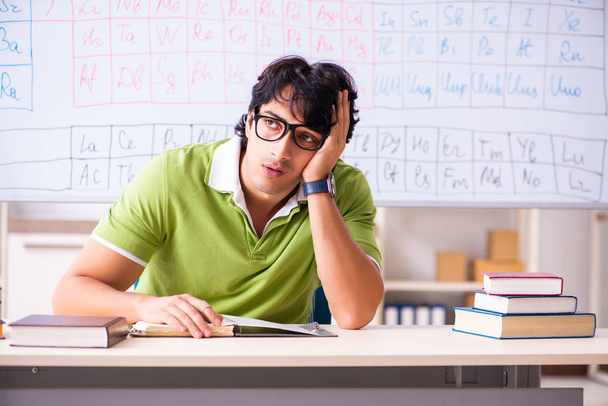 Giovane studente chimico di sesso maschile di fronte alla tavola periodica
  - Foto, immagini