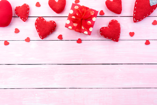 Concepto de fondo de San Valentín. Vista superior de la caja de regalo roja con corazón rojo hecho a mano sobre fondo de madera pastel rosa
. - Foto, imagen