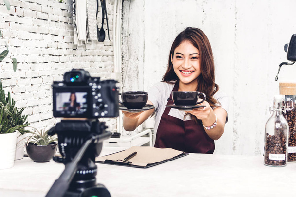 Retrato de mulher blogueira barista na frente da câmera gravando-se atrás do balcão em um café
 - Foto, Imagem