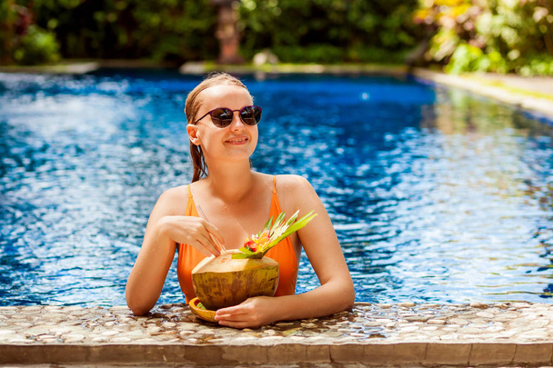 Girl with coconut in the pool - Φωτογραφία, εικόνα