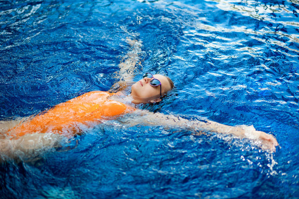 Mädchen mit Sonnenbrille schwimmt im Pool - Foto, Bild