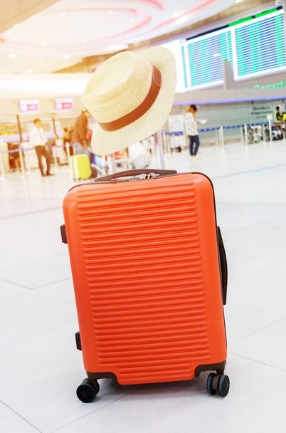 flamante equipaje naranja solo en la terminal del aeropuerto para viajar
 - Foto, Imagen