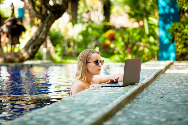 girl in the pool working on a laptop - Photo, Image