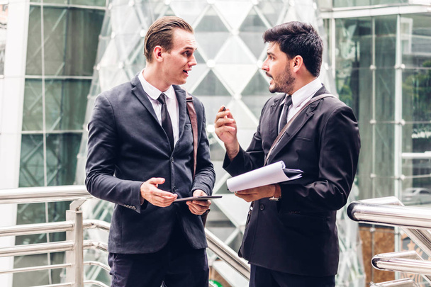 Kaksi hymyilevä liikemies työtoverit musta puku puhuminen ja walking.business ihmiset keskustelevat strategiasta nykyaikaisessa kaupungissa
 - Valokuva, kuva