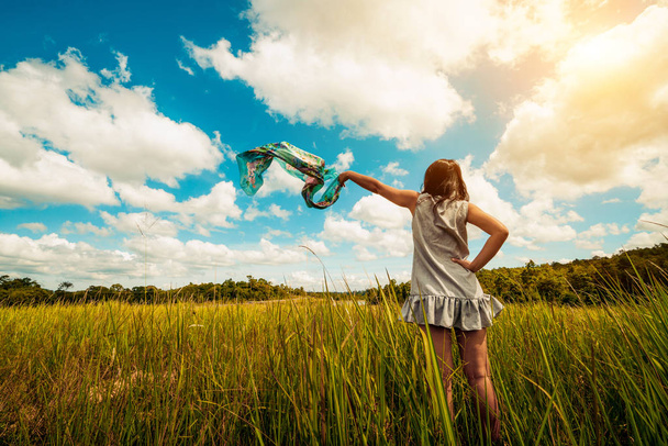 Mladá krásná žena na zelené trávě louce šíření zbraní do modré Slunečné nebe v letním dni. Koncept útočiště a meditace. - Fotografie, Obrázek