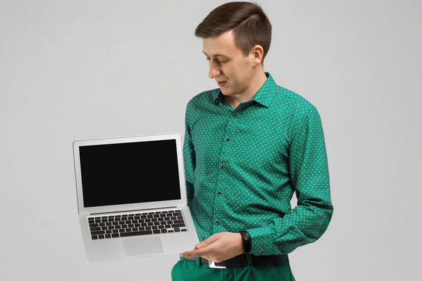 jeune homme avec ordinateur portable avec un écran vide dans ses mains est isolé sur fond de lumière
 - Photo, image