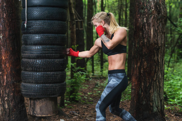 Boxer žena dělá zvedák kop cvičit venku. - Fotografie, Obrázek