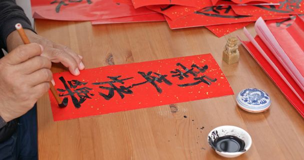 Stary człowiek pratice na piśmie chińskiej kaligrafii dla księżyca nowy rok słowa oznacza szczęśliwy nowy rok - Zdjęcie, obraz